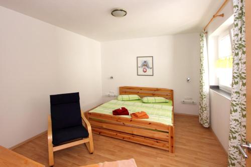 a bedroom with a bed and a chair at Haus Wibmer in Kals am Großglockner