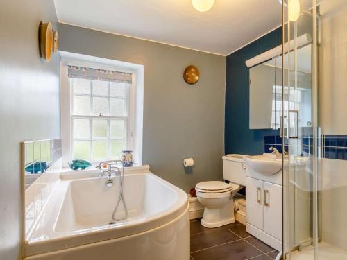 a bathroom with a tub and a toilet and a sink at 2 Bed in Fowey oc-76624 in Fowey