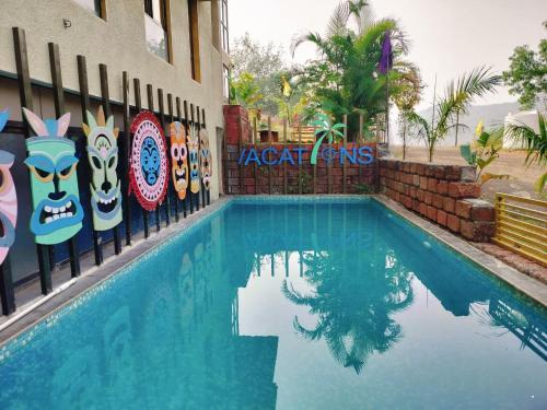 a swimming pool in front of a building at Athang Staycation in Diveagar