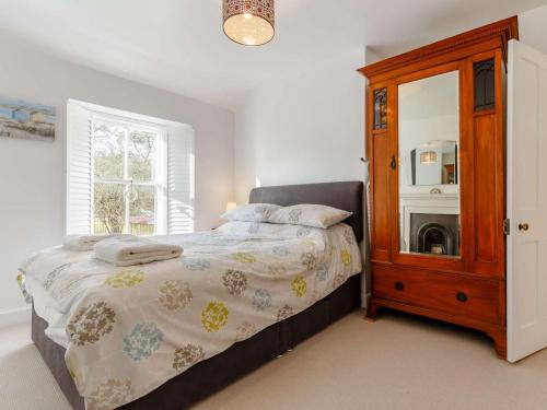 a bedroom with a bed with a dresser and a mirror at 2 Bed in Par- oc-81252 in Saint Blazey