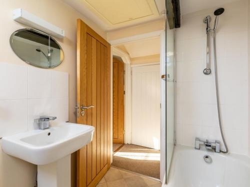 a bathroom with a sink and a shower with a mirror at 2 Bed in Helston oc-41378 in Cury