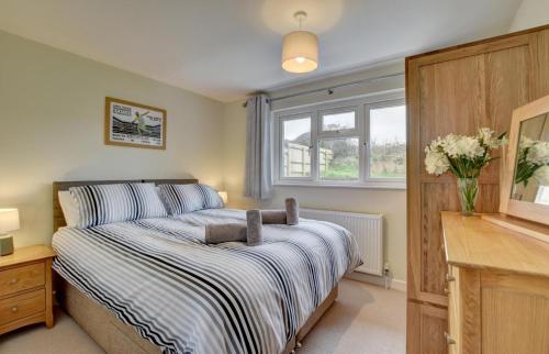 a bedroom with a bed and a vase of flowers at 3 Bed in Georgeham oc-halcy in Georgeham