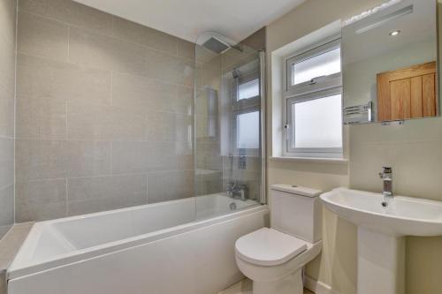 a bathroom with a tub and a toilet and a sink at 3 Bed in Georgeham oc-halcy in Georgeham