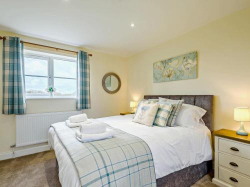 a bedroom with a large bed and a window at 2 Bed in Spilsby oc-91141 in Skendleby