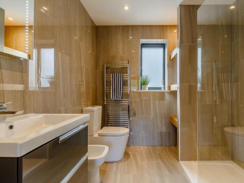 a bathroom with a sink and a toilet and a shower at 4 Bed in Bude oc-89355 in Poughill