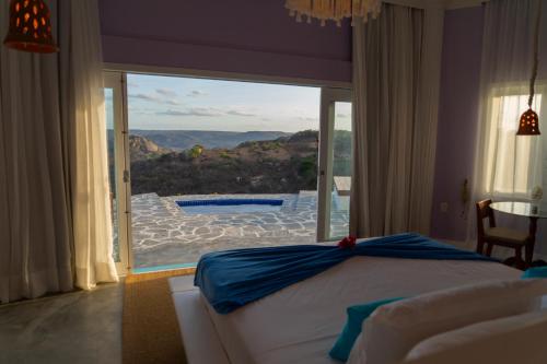 a bedroom with a bed and a view of a pool at Olymp Spa Boutique Hotel in Monte das Gameleiras