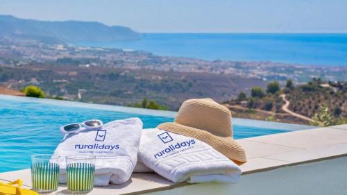 a pair of towels and a hat next to a pool at Villa Alborada Torrox by Ruralidays in Torrox