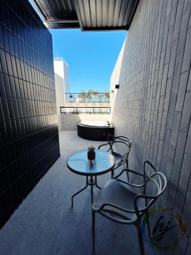 a patio with two chairs and a table on a building at Mares Cabo Branco 507 in Tambaú