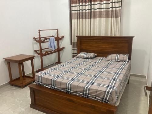 a bedroom with a bed with a plaid blanket at Siva Residencies in Wattala