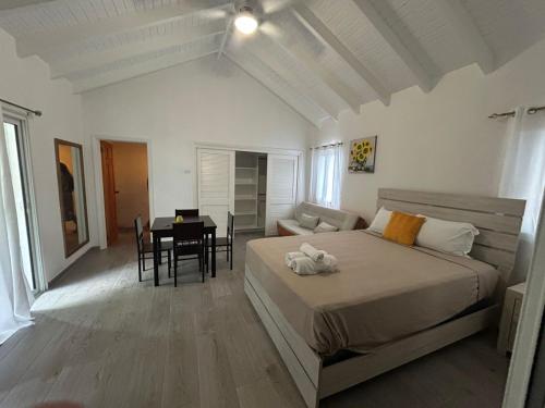 a bedroom with a bed and a dining room at Blue Sail Rooms in Koolbaai