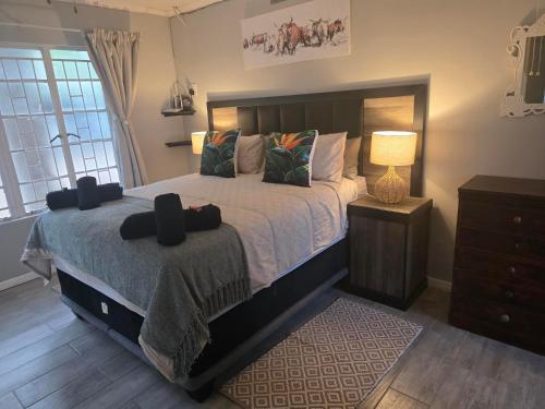 a bedroom with a large bed and a lamp at Nguni Rest in Barberton