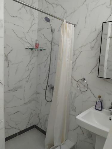 a bathroom with a shower curtain and a sink at La Residence D'Almée Apartment and Studio in Praslin