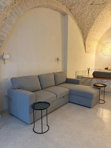 ein Wohnzimmer mit einem blauen Sofa und zwei Tischen in der Unterkunft Avril Suite in Noci