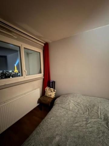 a bedroom with a bed and a window at Eiffel Tower view & Swimming Pool, Cosy appartment - Center in Paris