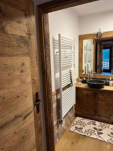 a bathroom with a sink and a mirror at L'Atelier du Temps - Chalet Crammont in Courmayeur