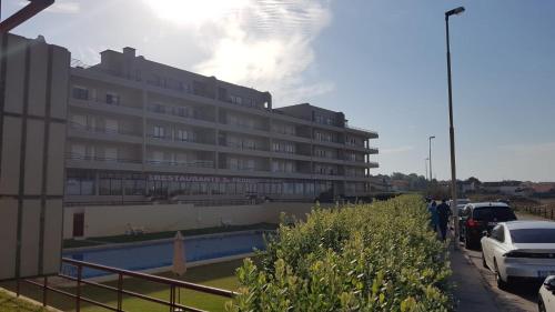 a large building with cars parked in front of it at Apartamento Mar & Sal in Mindelo