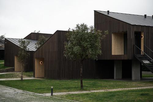 a wooden building with a tree in front of it at Paraíso Villas & Spa in Guimarães