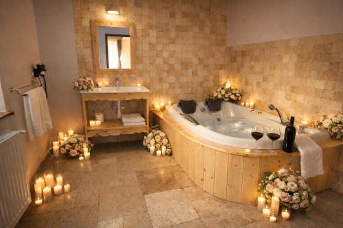 a large bathroom with a tub with candles and lights at Vila Belcin Spa&Retreat in Buşteni
