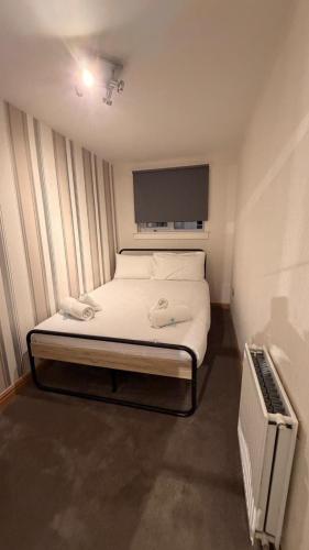 a small bedroom with a bed and a tv at Spacious Glasgow Group Stay in Glasgow