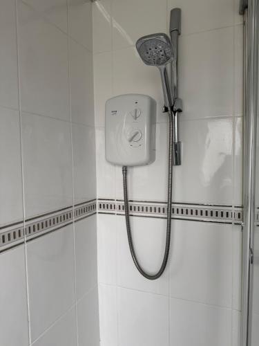 a shower with a shower head in a bathroom at Spacious Glasgow Group Stay in Glasgow