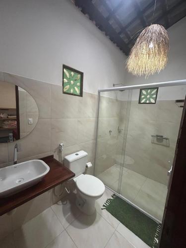 a bathroom with a shower and a toilet and a sink at Casa Bosque Guajiru in Trairi