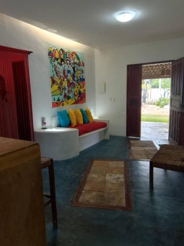 a living room with a couch and a painting on the wall at Casa Bosque Guajiru in Trairi