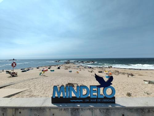 a sign on a beach with people on the beach at Apartamento Mar & Sal in Mindelo