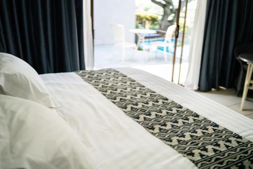 a white bed with a black and white comforter at De Wingerd Wijnland Lodge in Paarl