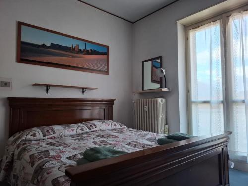 a bedroom with a bed and a large window at Rifugio Delia in Torre Pellice