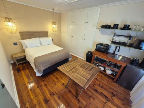 a bedroom with a bed and a table and a television at Vida Lenta in Springbok