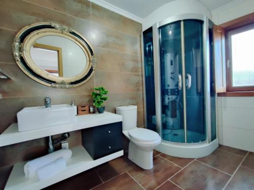 a bathroom with a sink toilet and a mirror at Casa da Telhada Pequena in Melgaço