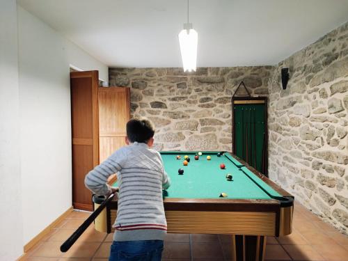 a young boy playing with a pool table at Casa da Telhada Pequena in Melgaço