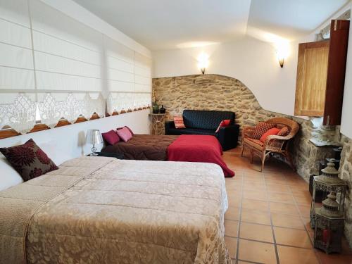 a hotel room with two beds and a couch at Casa da Telhada Pequena in Melgaço