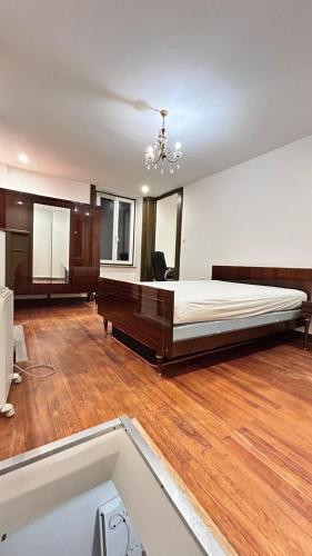 Studio duplex Meublé في شيربوغ أون كوتننتين: غرفة نوم كبيرة بها سرير كبير وأرضيات خشبية