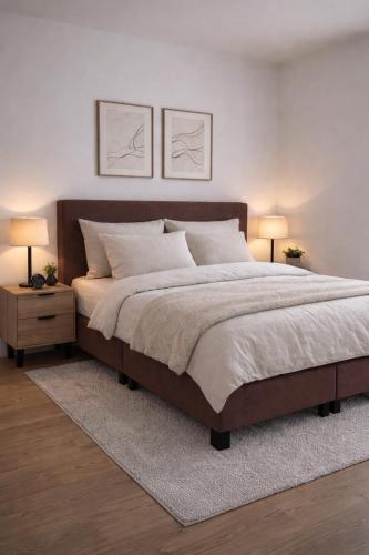 a bedroom with a large bed with two lamps at Burgschelde 61 in Oudenaarde