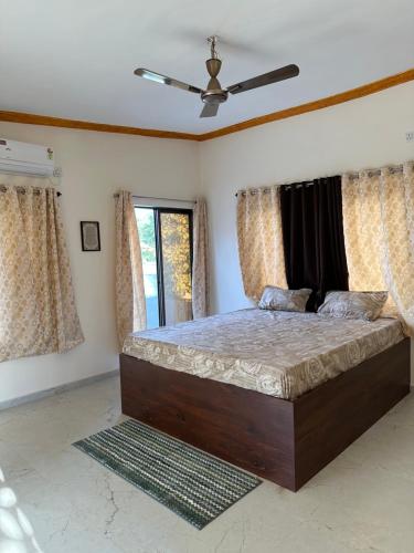 a bedroom with a bed with a ceiling fan at Moksha farms -3bhk private villa with pool and nature in Pālghar