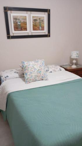 a bed with two pillows on it in a bedroom at Dpto amueblado con cochera descubierta in Río Tercero