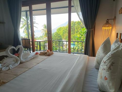 a bedroom with a bed with a large window at Marine House Koh Tao in Ko Tao