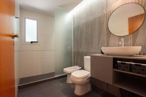 a bathroom with a sink and a toilet and a mirror at Casa Frida vivir sin prisa in Mar de las Pampas