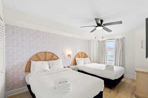 a hotel room with two beds and a ceiling fan at Wow! Oceanview 3 bedroom condo! Pool & private balcony in Myrtle Beach
