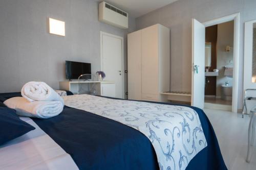 a bedroom with a bed with towels on it at Hotel Baia Azzurra in Taormina