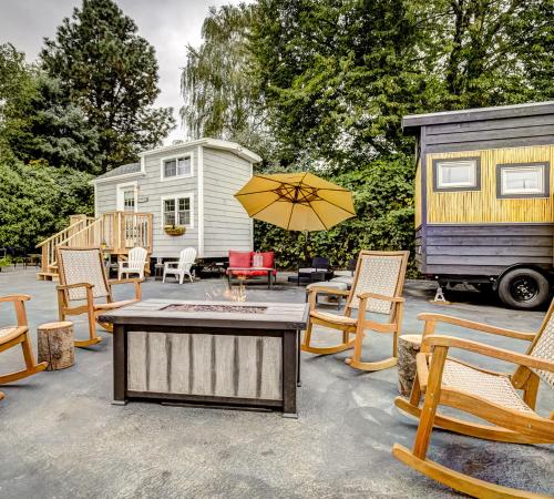 a patio with a table and chairs and a caravan at Tiny Digs - Hotel of Tiny Houses in Portland