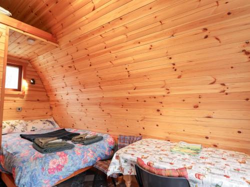 a room with two beds in a log cabin at Pod 1 in Belladrum