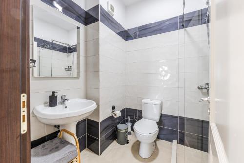a bathroom with a toilet and a sink at The Seabreeze Apartment by PikHost in Lalzit Bay
