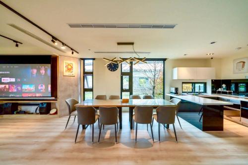 a kitchen and dining room with a table and chairs at 閒晃趣-包棟民宿-依訂房人數提供房間數 in Ch'i-wu-lao