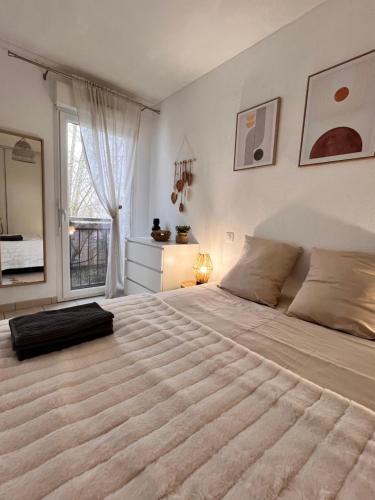 a bedroom with a large bed with a large window at Le bohème Chauraisien in Chauray