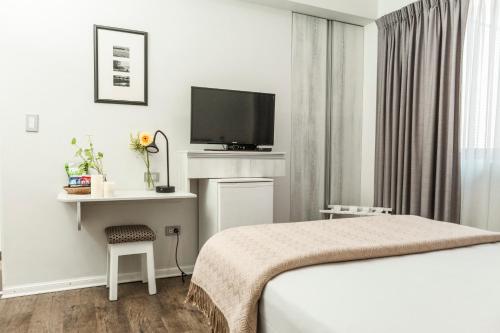 a hotel room with a bed and a flat screen tv at La Paz Apart Hotel in Lima