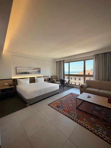 a large hotel room with a bed and a couch at The View - Saint George Hotel in Beirut