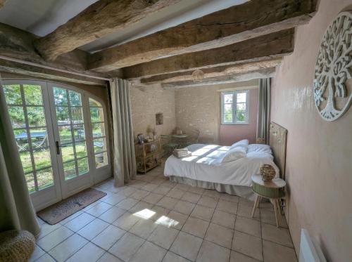 ein Schlafzimmer mit einem Bett und einem großen Fenster in der Unterkunft Saisonnée - Chambres d'Hôtes et Table d'Hôtes en Aveyron in Centrès