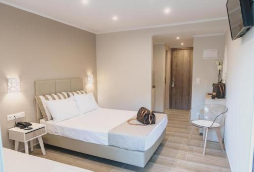 a white bedroom with a bed and a glass table at Ammos Beach Seaside Luxury Suites Hotel in Olympic Beach
